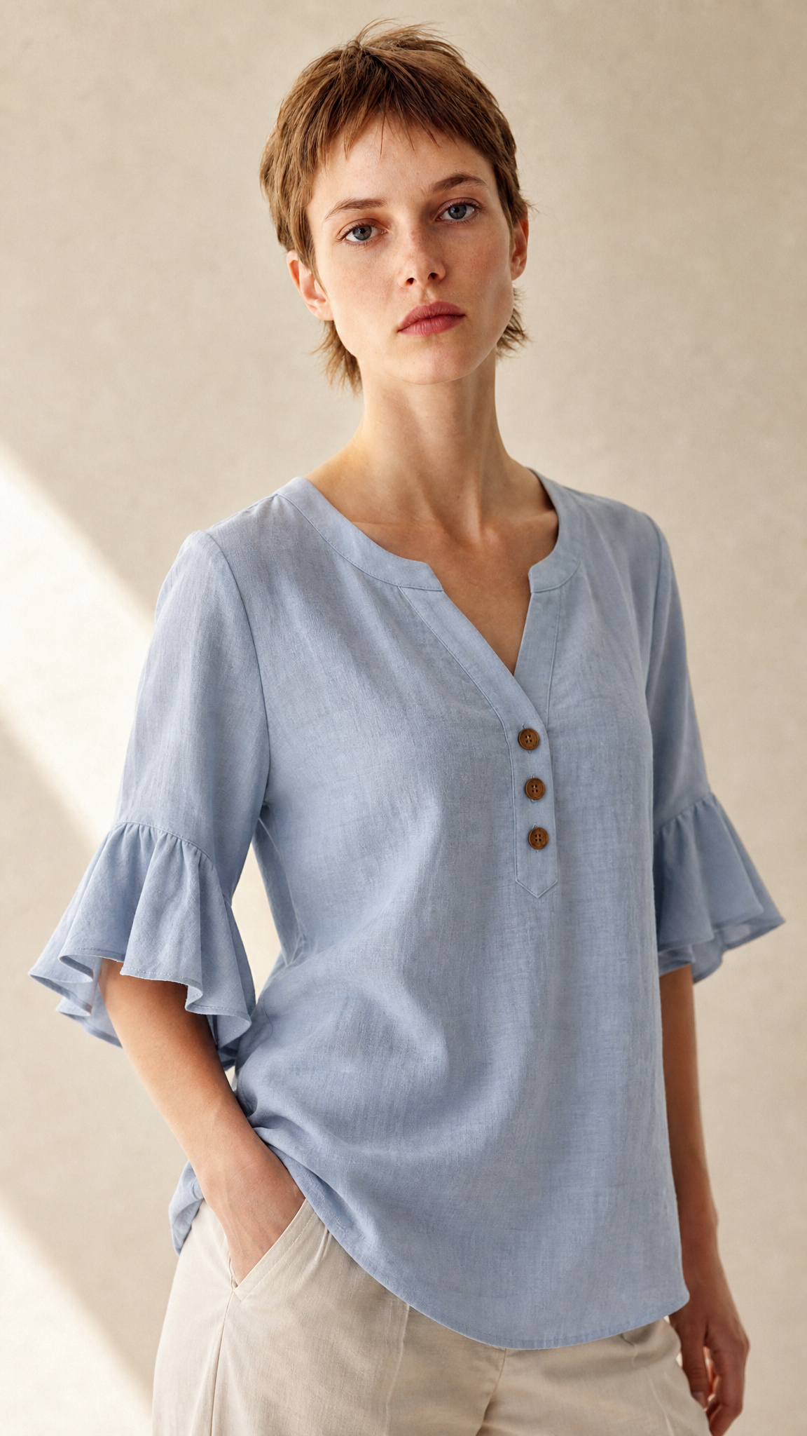Blouse Capucine bleue, détail boutons bois et manches volantées, mannequin en studio