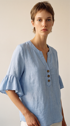 Blouse Capucine bleue à col V, mannequin en studio lumineux, plan taille
